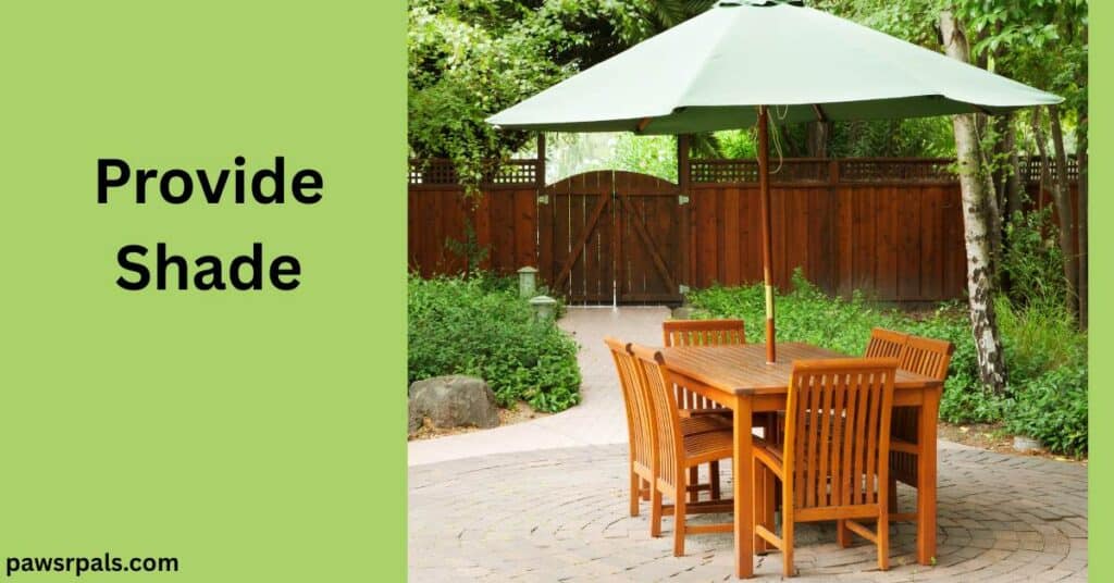 Provide Shade. Image on the right, wooden table with 6 wooden chairs around the table with a large green open umbrella in centre of the table, on an off-white bricks with greenery to either side and dark wooden fence in the background