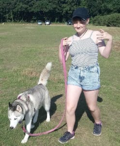 Why Its Important To Train Your Dog. Luna, the grey and white Siberian Husky walking beside Holly (12-year-old daughter), holding the pink lead loosely, in the park. Both relaxed, enjoying the walk.